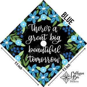 May include: A black graduation cap with a blue floral design and the text "There's a great big beautiful tomorrow". The cap is 9.5 inches wide.