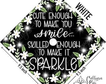 Puede incluir: Un gorro de graduación negro con flores blancas y hojas verdes alrededor del borde. El texto dice "Lo suficientemente lindo para hacerte sonreír... Lo suficientemente hábil para hacerlo brillar." El gorro mide 9,5 pulgadas por cada lado.