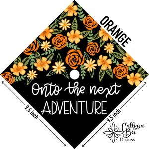 Pode incluir: Um gorro de gradua&ccedil;&atilde;o preto com design floral laranja e amarelo. O gorro tem 9,5 polegadas de largura e um c&iacute;rculo branco no centro. O texto "Onto the next ADVENTURE" est&aacute; escrito em branco na parte frontal do gorro.
