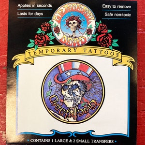 May include: A card with a colorful temporary tattoo of the Grateful Dead skull and crossbones logo. The card says "Temporary Tattoos" and "Contains 1 large & 2 small transfers."