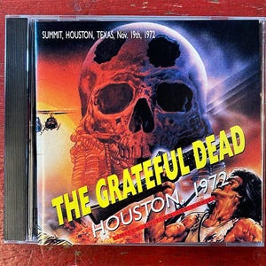May include: A CD case featuring a skull illustration with the text "THE GRATEFUL DEAD HOUSTON 1972." The cover includes the text "SUMMIT, HOUSTON, TEXAS, Nov. 19th, 1972" and "LIMITED EDITION 100 COPIES."