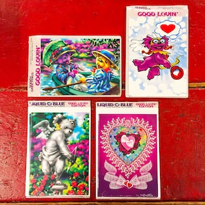 以下が含まれることがあります： バレンタインデーのテーマのグリーティングカードが4枚。カードには、ボートに乗ったクマのカップル、漫画のキューピッド、レースのデザインのハートなど、さまざまなデザインが施されています。カードはすべてプラスチックの包装に入っていて、「Good Lovin'」という文字が書かれています。