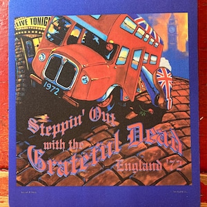 May include: A blue mouse mat with a colourful image of a red double-decker bus. The text reads "Steppin' Out with the Grateful Dead England '72". The background shows Big Ben and a Union Jack boot.