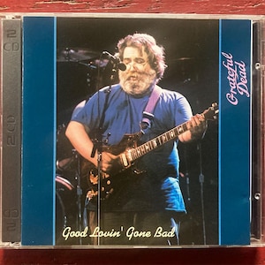 May include: A CD case featuring a live performance image of a musician playing a guitar. The text "Grateful Dead" is in pink script on the right side. The album title "Good Lovin' Gone Bad" is at the bottom. The case is clear plastic.