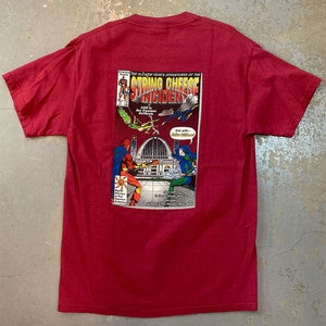 May include: Red t-shirt with a graphic of a comic book cover featuring the words "String Cheese Incident".