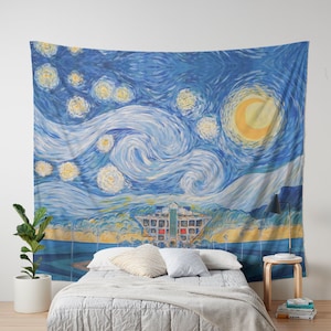 May include: A blue and yellow tapestry with a swirling sky and a bright yellow moon. The tapestry features a stylized cityscape with a building in the center. The tapestry is hanging on a wall above a bed with a white headboard and a white blanket.