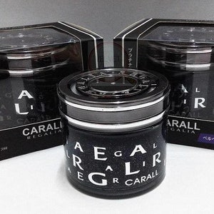 Puede incluir: Tres ambientadores de coche negros en cajas individuales. Los ambientadores son redondos y tienen una tapa plateada. Las cajas tienen texto japonés y las palabras "Carall Regalia" impresas en ellas.