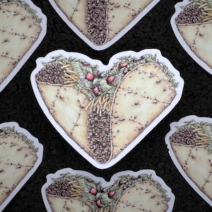 May include: A heart-shaped sticker with a detailed illustration of a taco filled with ground beef, lettuce, cheese, and tomatoes.