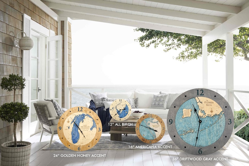 Puede incluir: Tres relojes de pared de madera con mapas n&aacute;uticos del lago Michigan, los Cayos de Florida y los Grandes Lagos. Los relojes tienen un di&aacute;metro de 61 cm, 41 cm y 91 cm y diferentes acabados de madera: miel dorada, acento americano y gris madera a la deriva.