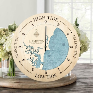 May include: A wooden tide clock with a blue and white map of Hampton, New Hampshire. The clock face shows the rising and falling tide levels with numbers 0 through 5.