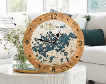 May include: A wooden clock with a map of Lake Minnetonka, Minnesota. The clock face is surrounded by a wooden frame with Roman numeral hour markers. The clock hands are black.