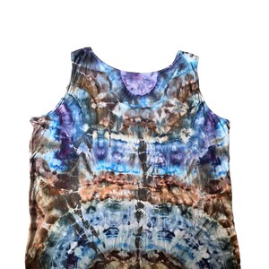 May include: A tie-dye tank top with a blue, brown, and purple color scheme. The tank top has a relaxed fit and a scoop neck.