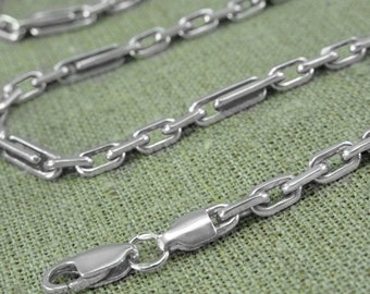 May include: A silver chain necklace with a flat, rectangular link design. The chain has a lobster claw clasp.