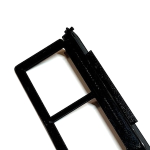May include: Black plastic filter holder with two rectangular openings. The holder has a hinged lid and a latch.