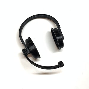 Puede incluir: Auriculares de plástico negro con diadema y almohadillas. Los auriculares están diseñados para ajustarse sobre las orejas.