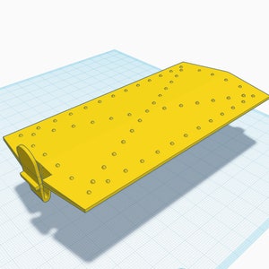 May include: A yellow plastic plate with a grid of holes. The plate has a small yellow plastic tab on the side.