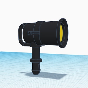 Könnte beinhalten: Ein schwarzer Scheinwerfer mit gelber Linse. Der Scheinwerfer hat einen Griff und einen zylindrischen Körper. Die Basis des Scheinwerfers ist ein kleinerer Zylinder. Der Hintergrund ist ein hellblaues Gitter.