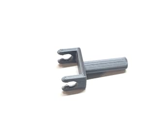 May include: A gray plastic 3D printed part with two prongs on one end and a cylindrical shaft on the other.
