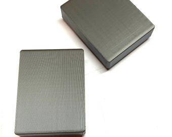 May include: Two gray rectangular blocks made of a textured material. The blocks are similar in size and shape.