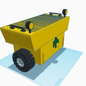 May include: A yellow toy dumper truck with a black tyre and a black grate on the bed. The truck has two black lights on the back.