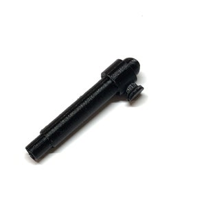 Puede incluir: Una pistola de juguete de plástico negro con un cañón redondeado y una pequeña empuñadura. La pistola mide aproximadamente 12,5 cm de largo.