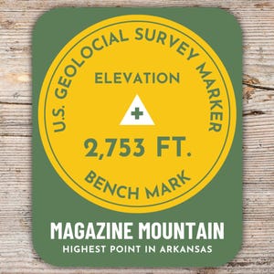 Könnte beinhalten: Ein runder Aufkleber in Grün und Gelb mit dem Text "U.S. Geological Survey Marker" und "Elevation 2,753 FT. Bench Mark". Der Aufkleber trägt außerdem den Text "Magazine Mountain Highest Point in Arkansas".