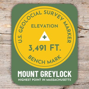 Könnte beinhalten: Ein runder Aufkleber in Grün und Gelb mit dem Text "U.S. Geological Survey Marker" und "Elevation 3,491 FT. Bench Mark". Der Aufkleber trägt außerdem den Text "Mount Greylock Highest Point in Massachusetts".