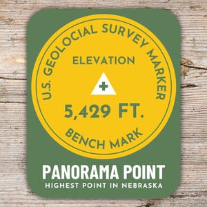 Könnte beinhalten: Ein grüner und gelber Aufkleber mit dem Text "U.S. Geological Survey Marker" und "Panorama Point, Highest Point in Nebraska". Der Aufkleber enthält auch den Text "Elevation 5,429 FT. Bench Mark".