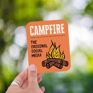 May include: An orange square sticker with the word "CAMPFIRE" in white block letters. Below, the text reads "THE ORIGINAL SOCIAL MEDIA". A graphic of a campfire with flames and logs is featured.