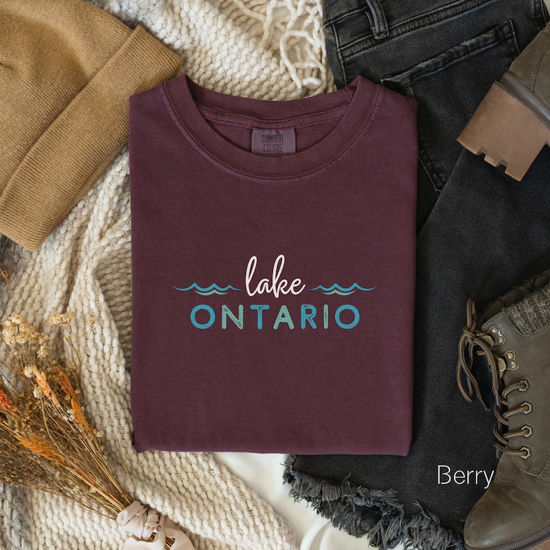 May include: A maroon t-shirt with the text "lake ONTARIO" in blue and green lettering with wavy lines above and below the text.