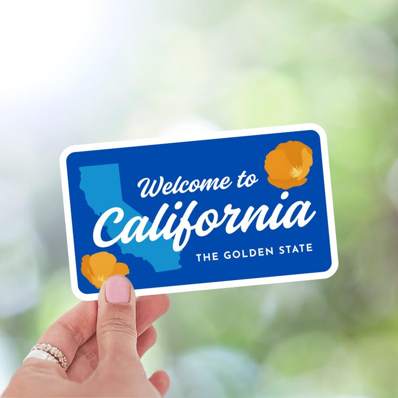 May include: A blue rectangular sticker with rounded corners, featuring the text "Welcome to California" and "The Golden State." The sticker includes a light blue outline of California and orange poppy illustrations.