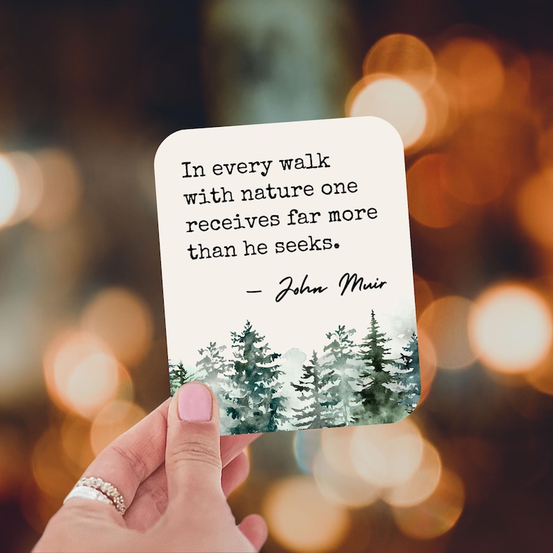 May include: A white card with a quote by John Muir about nature. The quote reads "In every walk with nature one receives far more than he seeks." The card has a watercolor illustration of a forest with green trees.