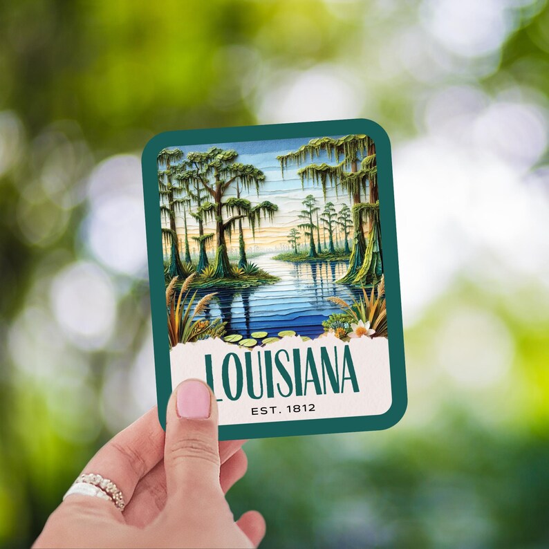 May include: A teal blue rectangular sticker with a scenic image of a river flowing through a swamp with cypress trees. The text "LOUISIANA EST. 1812" is printed on the sticker.