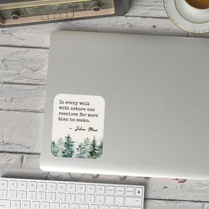 May include: A white laptop sticker with a watercolor illustration of a forest and a quote by John Muir: "In every walk with nature one receives far more than he seeks."