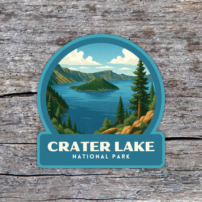 May include: A round sticker featuring a scenic view of Crater Lake National Park. The image shows a blue lake surrounded by green trees and mountains under a blue sky with clouds. The text "CRATER LAKE NATIONAL PARK" is displayed at the bottom.