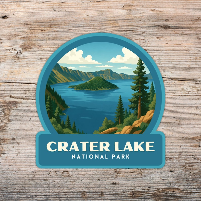May include: A teal and blue sticker featuring a scenic illustration of Crater Lake National Park. The image shows a lake with an island, surrounded by mountains and trees. The text "CRATER LAKE NATIONAL PARK" is displayed at the bottom.