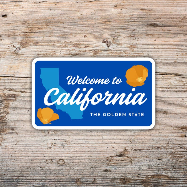 May include: A rectangular sticker with a blue background and white border. The sticker features the text "Welcome to California" and "California" in white script. A light blue outline of California and two orange poppies are also present. The text "THE GOLDEN STATE" is at the bottom.
