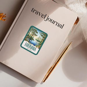 May include: A vintage-style sticker featuring a scenic landscape of a swamp with tall trees and a body of water. The sticker has a teal border and the text "LOUISIANA EST. 1812" in white.