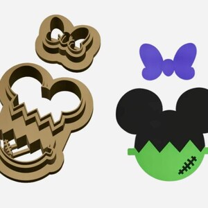 May include: A set of two cookie cutters, one shaped like a Frankenstein's monster Mickey Mouse and the other shaped like a bow. The Frankenstein's monster Mickey Mouse cookie cutter is green with black ears and a stitched scar. The bow cookie cutter is purple.