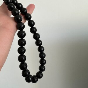 May include: A black beaded necklace with round beads.