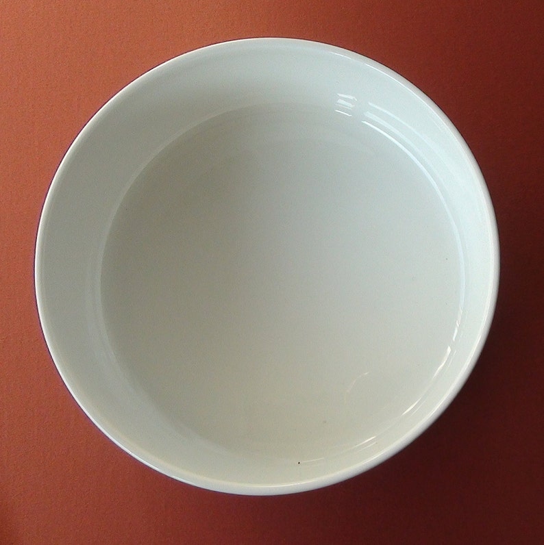 May include: A white ceramic bowl with a smooth, rounded interior. The bowl is empty and appears to be new.
