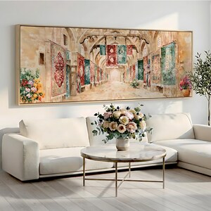 May include: A large rectangular framed wall art print depicting a stone corridor lined with hanging ornate rugs in shades of red, green, and blue. The scene features arched ceilings, stone pillars, and floral arrangements on the sides.