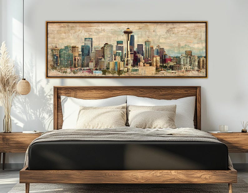 May include: A framed canvas print of a cityscape, featuring a skyline with tall buildings and a prominent Space Needle. The artwork has a vintage, watercolor style with muted colors, and is displayed above a wooden bed frame.