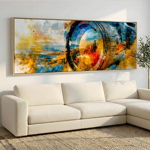 Può includere: Un'opera d'arte murale rettangolare che presenta una vivace stampa in stile acquerello di un obiettivo fotografico sovrapposto a un paesaggio. L'opera mostra una miscela di tonalità gialle, arancioni e blu, incorniciata in legno chiaro.