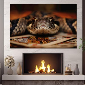 Puede incluir: Primer plano de la cabeza de una serpiente, con patrones detallados de escamas marrones, negras y beige. La serpiente descansa sobre cartas de juego, con el foco en su mirada intensa. Impresión en lienzo.