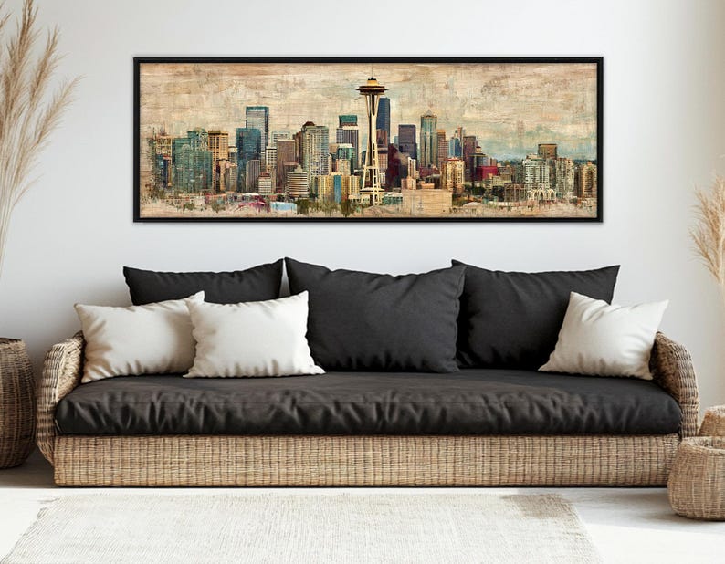 May include: A framed art print of the Seattle skyline, featuring the Space Needle and various buildings in shades of blue, brown, and gold. The artwork has a vintage, watercolor-like aesthetic, with a black frame.