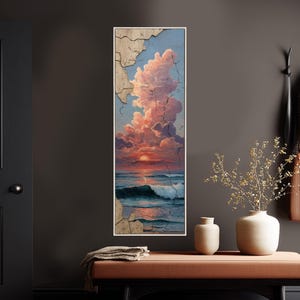 Könnte beinhalten: Ein vertikal gerahmtes Gemälde zeigt einen Sonnenuntergang über dem Meer. Der Himmel ist mit rosa und orangefarbenen Wolken gefüllt, und das Wasser hat Wellen. Der Rahmen hat ein rissiges, verwittertes Aussehen. Das Gemälde wird an einer dunkelgrauen Wand ausgestellt.