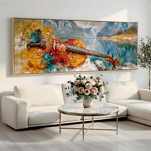 Puede incluir: Una impresión artística rectangular enmarcada que muestra un violín detallado con tallas ornamentadas, en tonos dorados, naranjas y azul verdoso. El instrumento descansa sobre un fondo de un lago de montaña sereno, picos nevados y árboles dorados.