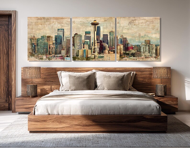 May include: A three-panel wall art set depicting a cityscape with a prominent Space Needle. The artwork features a vintage, textured effect with muted colors of blue, green, and brown. The art hangs above a wooden bed frame with matching nightstands and lamps.