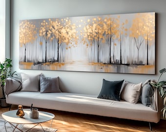 May include: Abstract painting of a forest scene with gold and gray trees. The trees are silhouetted against a light gray background. The painting is framed and hanging on a wall.
